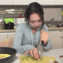 a woman is cutting vegetables on a cutting board