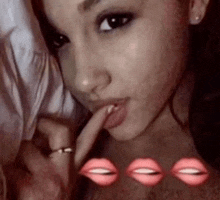a close up of a woman taking a selfie with her finger in her mouth