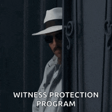 a man wearing a hat and sunglasses is peeking through a door with the words witness protection program below him