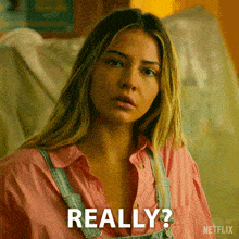 a woman wearing overalls and a pink shirt has the word really on her face