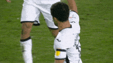 a soccer player wearing a white jersey with the letter j on the sleeve