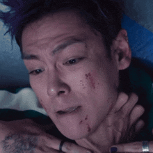 a close up of a man 's face with a tattoo on his arm