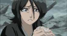 a girl with black hair is crying and holding something in her hands