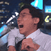 a man in a white shirt and tie is laughing with his mouth open