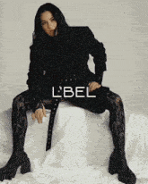 a woman is sitting on a bed with the word label on the bottom right