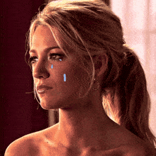 a woman with tears running down her face is wearing earrings