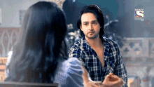 a man and a woman are looking at each other and talking .