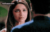 a woman is looking over a man 's shoulder and making a funny face .