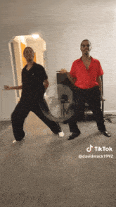 two men are dancing in a living room with a tiktok written on the bottom
