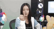 a girl wearing a jacket that says ichoi on it is giving the middle finger