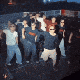 a group of people are dancing and one of them is wearing a shirt that says ' abercrombie & fitch ' on it
