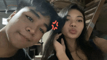 a boy and a girl are posing for a picture and the girl has a red star on her forehead