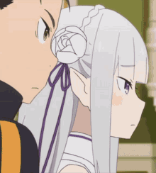 a boy and a girl are looking at each other and the girl has a flower in her hair