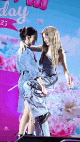 a woman is carrying another woman on her shoulders in front of a sign that says day 25