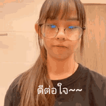 a girl wearing glasses and a black shirt has a foreign language sticker on her face