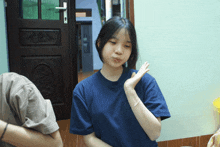 a girl wearing a blue shirt making a funny face
