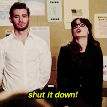 a man and a woman standing next to each other with the words shut it down written in yellow