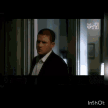 a man in a suit and tie is waving his hand .