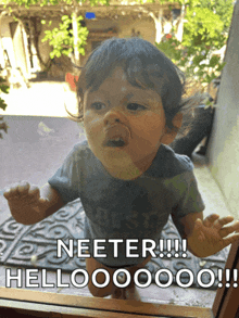 a baby in a blue shirt says neeter hello