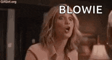 a woman is making a funny face and blowing a kiss in a room .