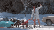 a man in a bathrobe is standing in the snow holding a beer and saying happy birthday shutter 's full