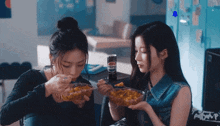 two girls are eating a bowl of food and drinking a can of pepsi