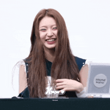 a woman is smiling in front of a sign that says sound