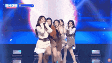a group of girls are performing on a stage with the word show on the bottom right