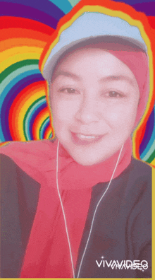 a woman wearing a hijab and a hat is smiling in front of a colorful background that says vivavideo on it