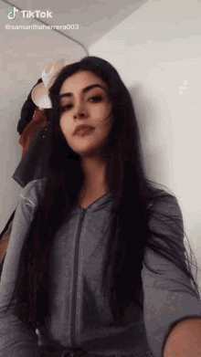 a woman with long black hair is taking a selfie with a tiktok watermark