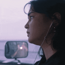 a close up of a woman 's face with ear buds on