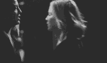 a black and white photo of a man and a woman dancing together .