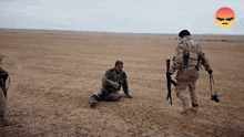 a man in a military uniform is kneeling down in a desert