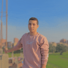 a young man wearing a pink sweater that says baby