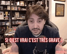 a man is sitting in front of a microphone with the words si c'est vrai c'est tres grave