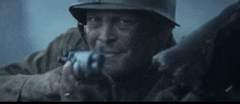 a man in a helmet is holding a gun in his right hand .