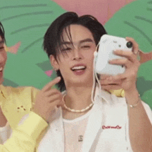 a man is taking a selfie with a cell phone .