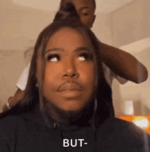 a man with a beard is getting his hair done .