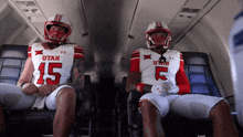 two utah football players are sitting next to each other