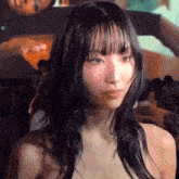 a woman without a shirt is looking at the camera with a blurry background