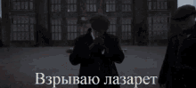 a man in a suit stands in front of a large brick building with a caption in a foreign language