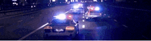 a couple of cars are driving down a highway at night with lights on .