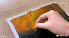 a person is painting a picture with deep yellow and medium yellow