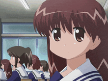 a girl with red hair is sitting in a classroom with other students