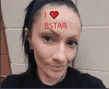 a woman with a heart on her forehead and the words `` i love bstar '' written on her forehead .