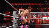 two men are wrestling in a wrestling ring with the letter w on the ring