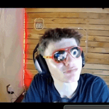 a man wearing sunglasses and headphones stands in front of a sign that says 66