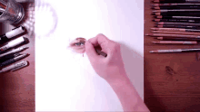 a person is drawing a woman 's eye on a piece of paper with colored pencils