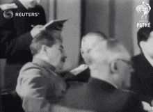 a black and white photo of a group of men with reuters written on the top