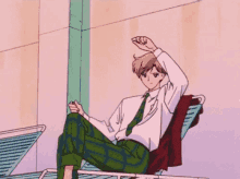a man in a suit and tie is sitting on a chair with his legs crossed .